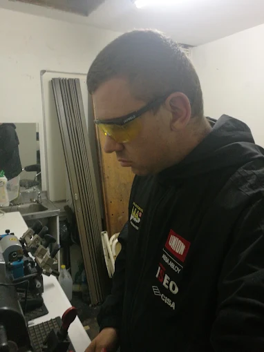 An AAA Locksmiths technician cutting a key at the branch workshop